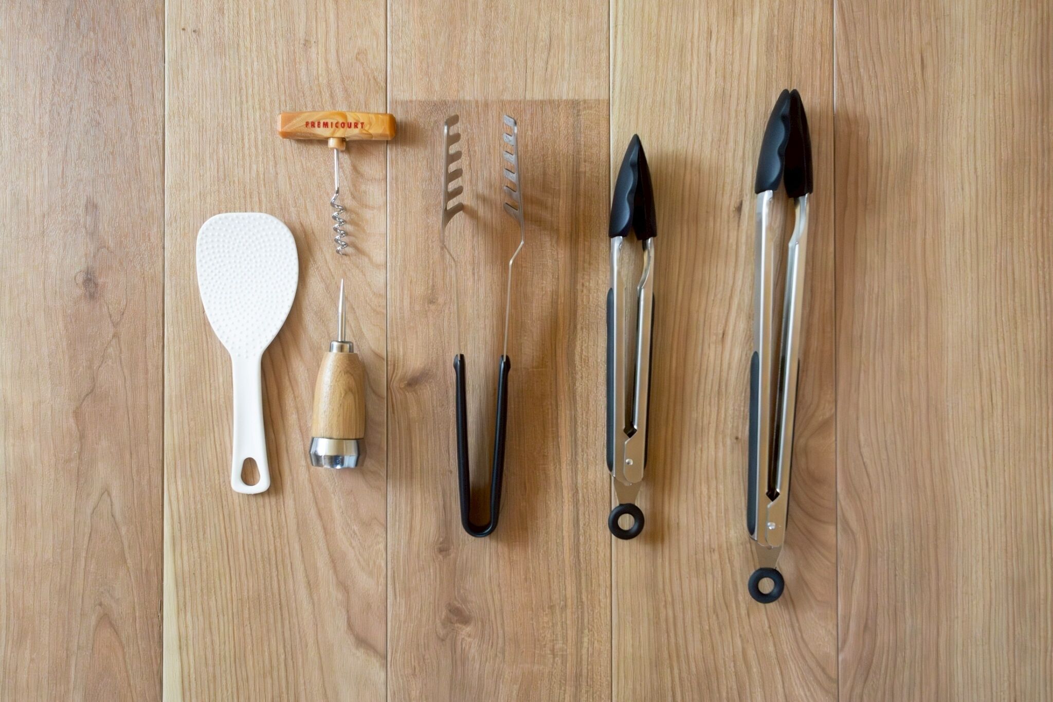 Various kitchen utensils laid out on a wooden surface.
