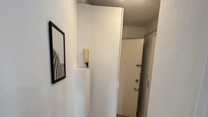 A narrow hallway with wooden flooring, white walls, and a ceiling light fixture. - Studio Croisette 3 mint on foot, comfortable and relaxing. (Cannes)