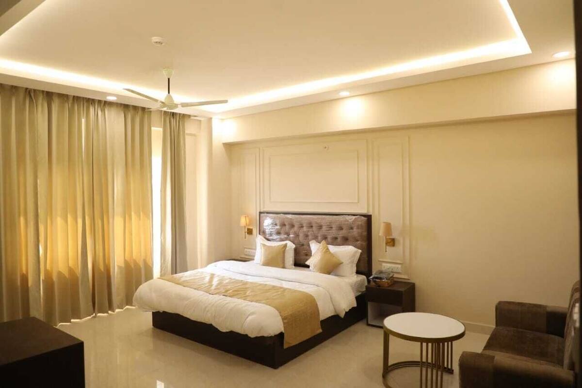 Une chambre d’hôtel moderne avec un grand lit, une table ronde et un canapé.