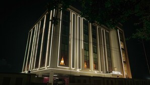 Un bâtiment moderne doté de bandes lumineuses verticales et d’une enseigne indiquant le nom « Celestial ».