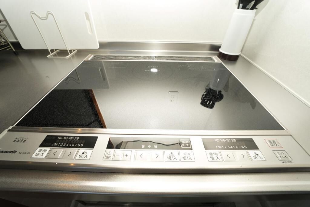 A kitchen with a built-in stove, control panel, and a white countertop.