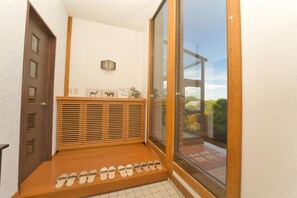 A small, cozy room with a built-in bench and a large window offering a view of the outdoors. - Toya Blue (Toyako)