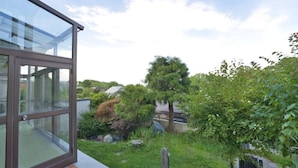 Un bâtiment moderne doté de grandes fenêtres en verre et d’un jardin bien entretenu, agrémenté de divers arbres et arbustes.