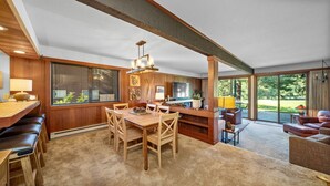 A spacious living area with a wooden dining table, a sofa, and a TV. - 3BR on Graeagle Meadows Golf Course (Graeagle)