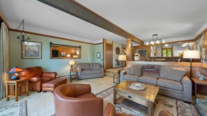 A spacious living room with leather sofas, a wooden coffee table, and a fireplace. - 3BR on Graeagle Meadows Golf Course (Graeagle)