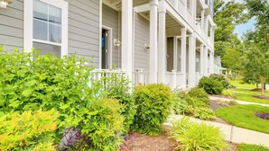A two-story building with a covered porch and a well-maintained garden. - Walk to Ocean: Group Getaway in Virginia Beach! (Virginia Beach)