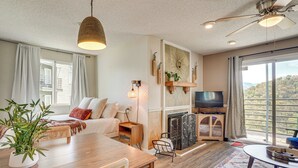 Un salon spacieux avec une table à manger en bois, un canapé, un téléviseur et une cheminée.