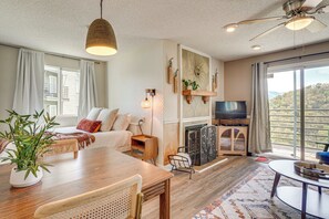 Un salon spacieux avec une table à manger en bois, un canapé, un téléviseur et une cheminée.