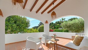 A terrace with white chairs, a wicker sofa, and a small table. - Tres Corazones - Moraira, Costa Blanca (Moraira)