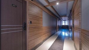A hallway with wooden paneling and a sign indicating room number 307. - Zzam Hotel (Jeonju)