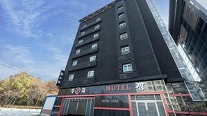 A multi-story building with a sign indicating it is a motel. - Zzam Hotel (Jeonju)