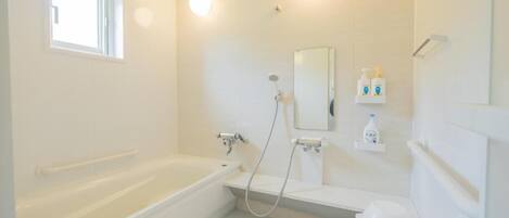 Un baño moderno con bañera, ducha, inodoro y ventana.