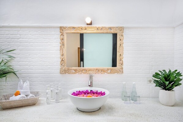 A bathroom with a white sink, a decorative mirror, and a potted plant. - Cozy 3 BR Villa in Seminyak With Promo Rate (Seminyak)