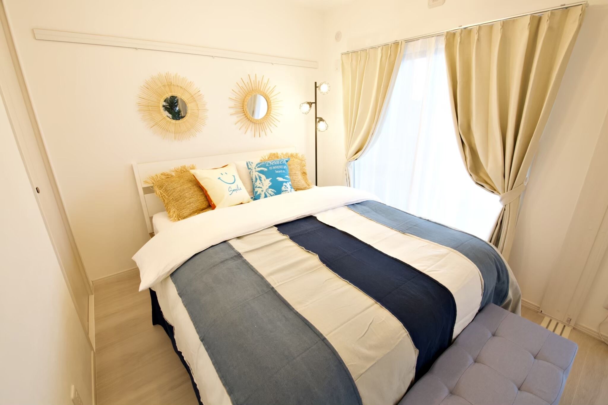 A neatly arranged bedroom with a large bed, a bedside table, and a bench.