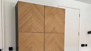 Une chambre dotée d’une grande armoire, d’un lit, d’un bureau et d’un luminaire fixé au mur.