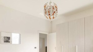 Un dormitorio moderno con cama, armario y un pasillo que lleva a otra habitación.