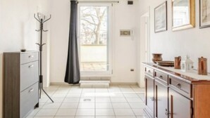 Una cocina moderna con suelo de baldosas, un mueble de madera y una lámpara colgante.