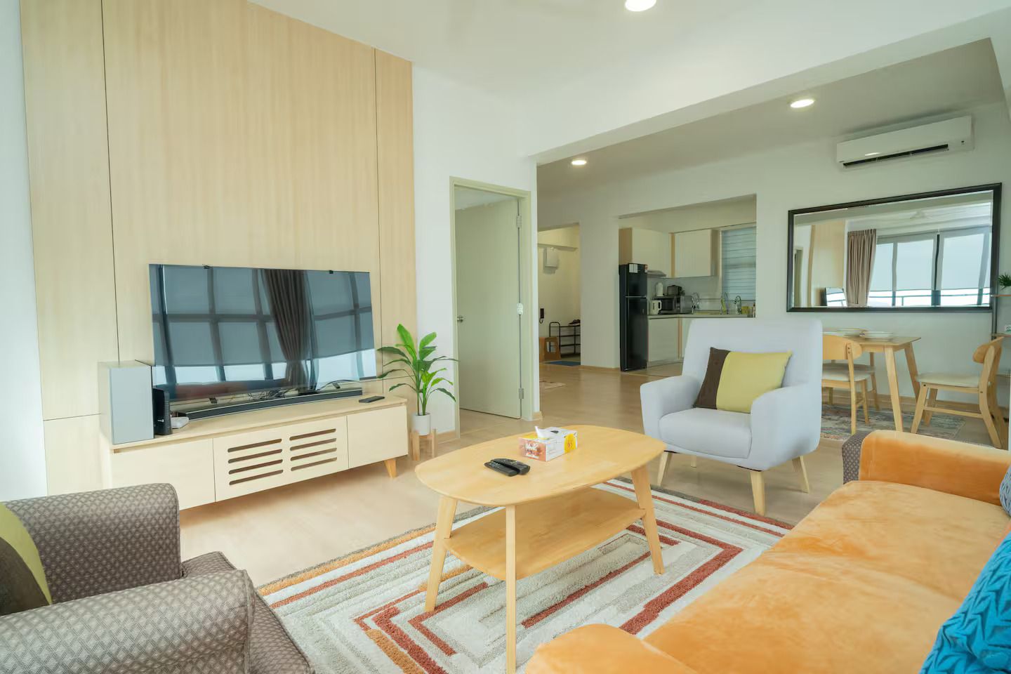 Ein modernes Wohnzimmer mit Flachbildfernseher, Couchtisch und Sofa.