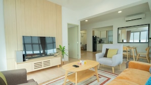 Uma sala de estar moderna com televisão de tela plana, mesa de centro e sofá.