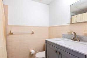A bathroom with a toilet, sink, and towel rack. - Studio Condo in Prime Location with a Pool (Wildwood)