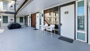 Un bâtiment doté d’un espace extérieur abrité, d’un escalier et d’une porte portant le numéro « 108 ».