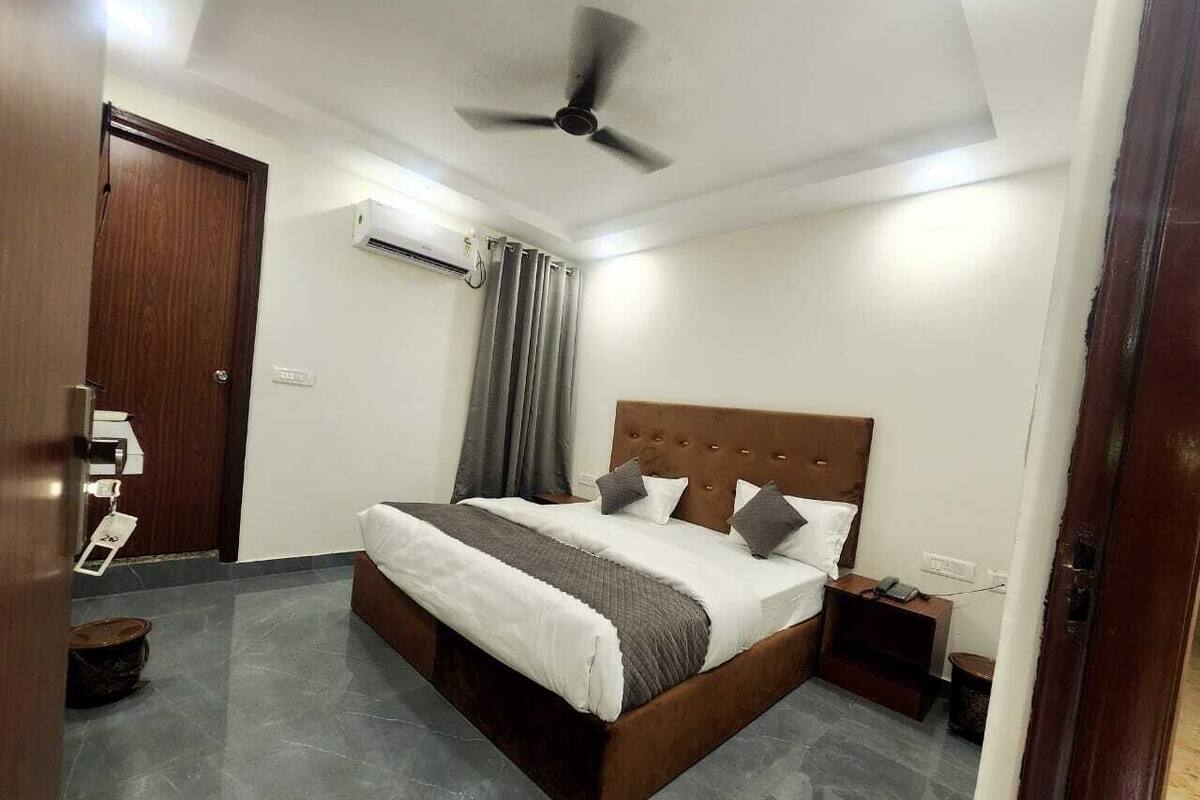 A bedroom with a bed, a ceiling fan, a nightstand, and a door.