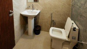 Une salle de bain avec un lavabo, un miroir, des toilettes et une porte en bois.