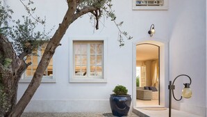 A white building with a large window, a potted plant, and a lamp post. - Villa in Vabriga with Pool and Private Garden (Vabriga)