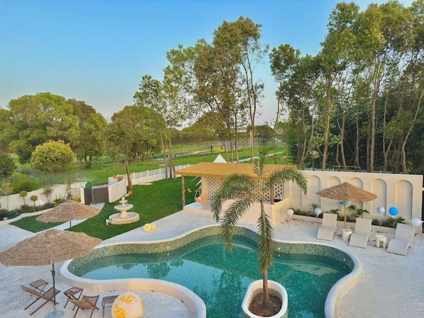 Piscina a l'aire lliure de temporada, para-sols i gandules