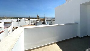 Una terrazza sul tetto con vista libera sul mare e sugli edifici in lontananza.