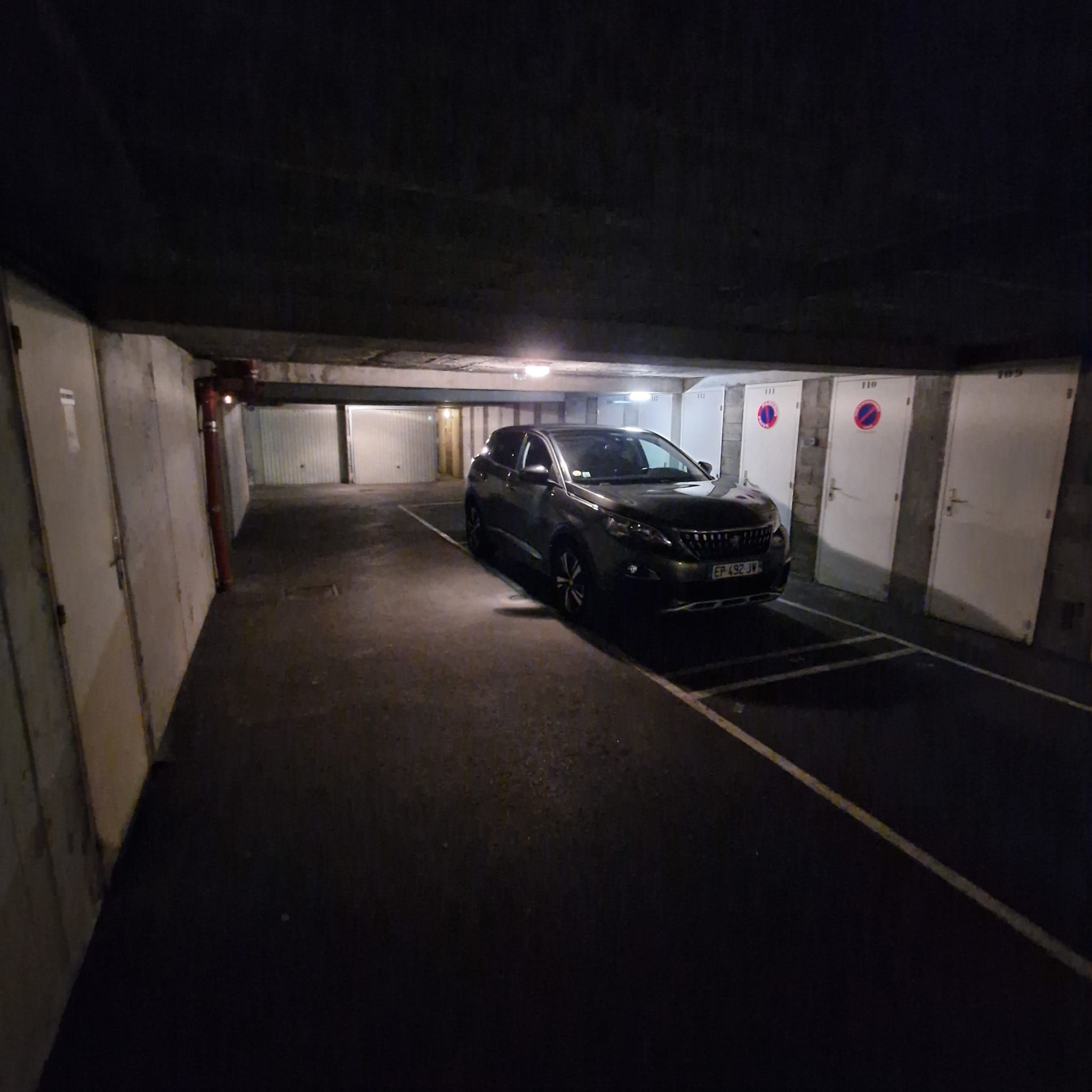 En parkeringskælder med en bil parkeret på en reserveret plads.