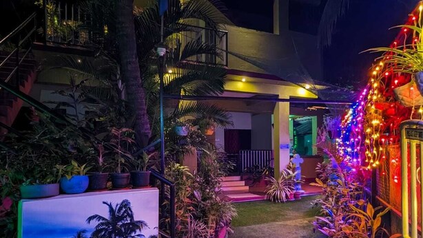 Ein hell erleuchteter Innenbereich mit Garten und einem Schild mit der Aufschrift 'Luciano Guest House'.