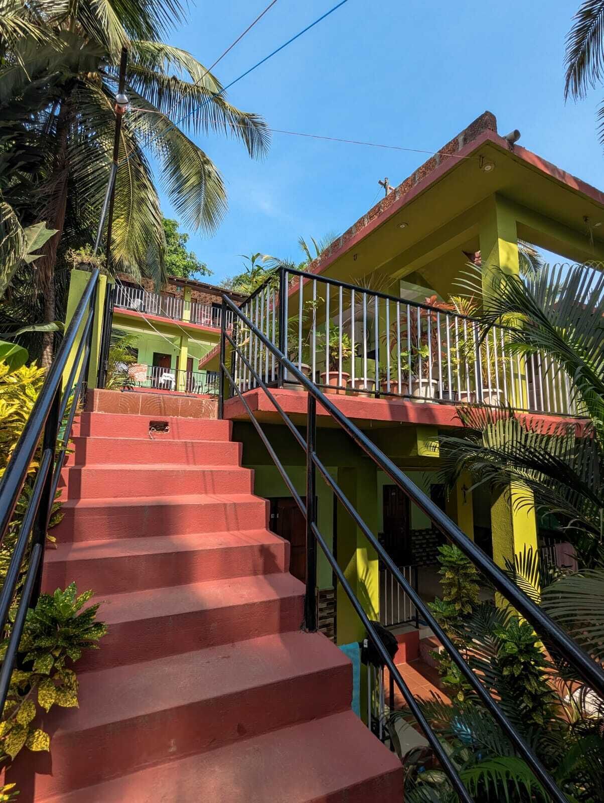 A multi-level building with a red staircase and a balcony.