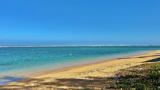 A beach with clear blue water, a sandy shore, and a clear sky. - *VILLA SOUS LES PALMES* - 170 m from the lagoon (Saint-Paul)