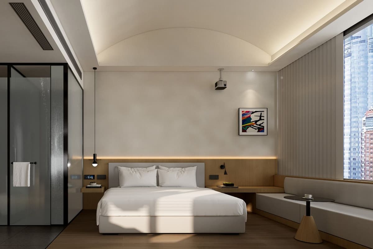 Ein modernes Hotelzimmer mit einem großen Bett, einem begehbaren Kleiderschrank, einem Nachttisch und einem Fenster mit Blick auf die Stadt.