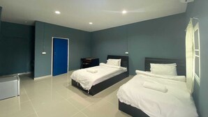 A room with two beds, a desk, and a door.