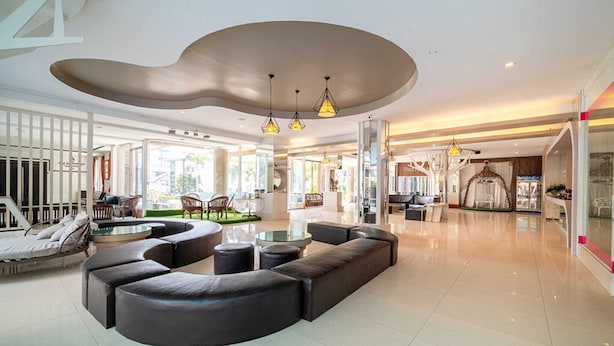A spacious lobby with a curved seating area, a reception desk, and a view of the outside.