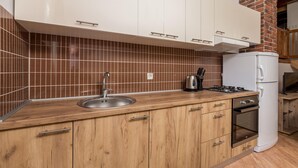 A kitchen with wooden cabinets, a stainless steel sink, a gas stove, and a built-in oven.