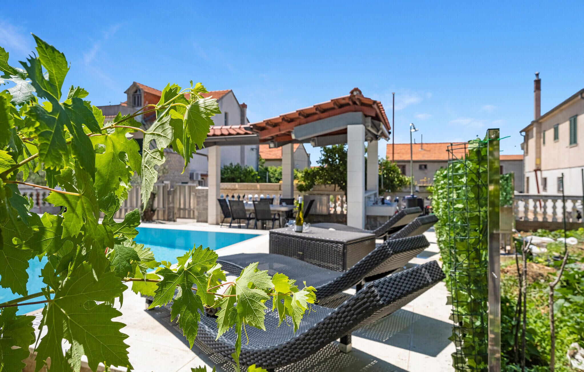 A pool area with lounge chairs and a pergola.