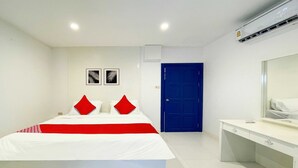 Una habitación de hotel moderna con una cama grande, un escritorio y una puerta azul.