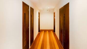 A narrow hallway with wooden doors on both sides and a striped floor.
