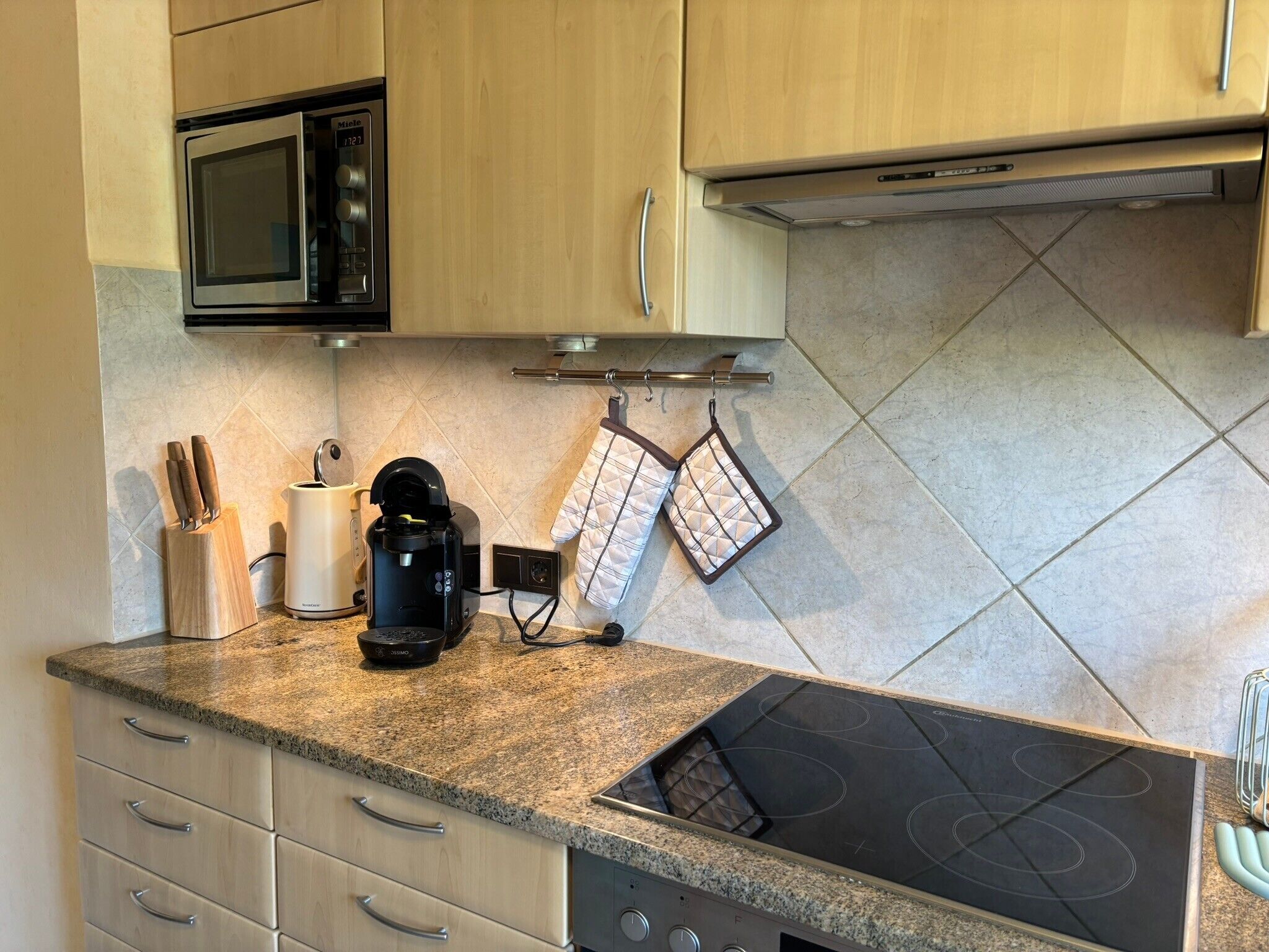 A kitchen with a microwave, coffee maker, and stove.