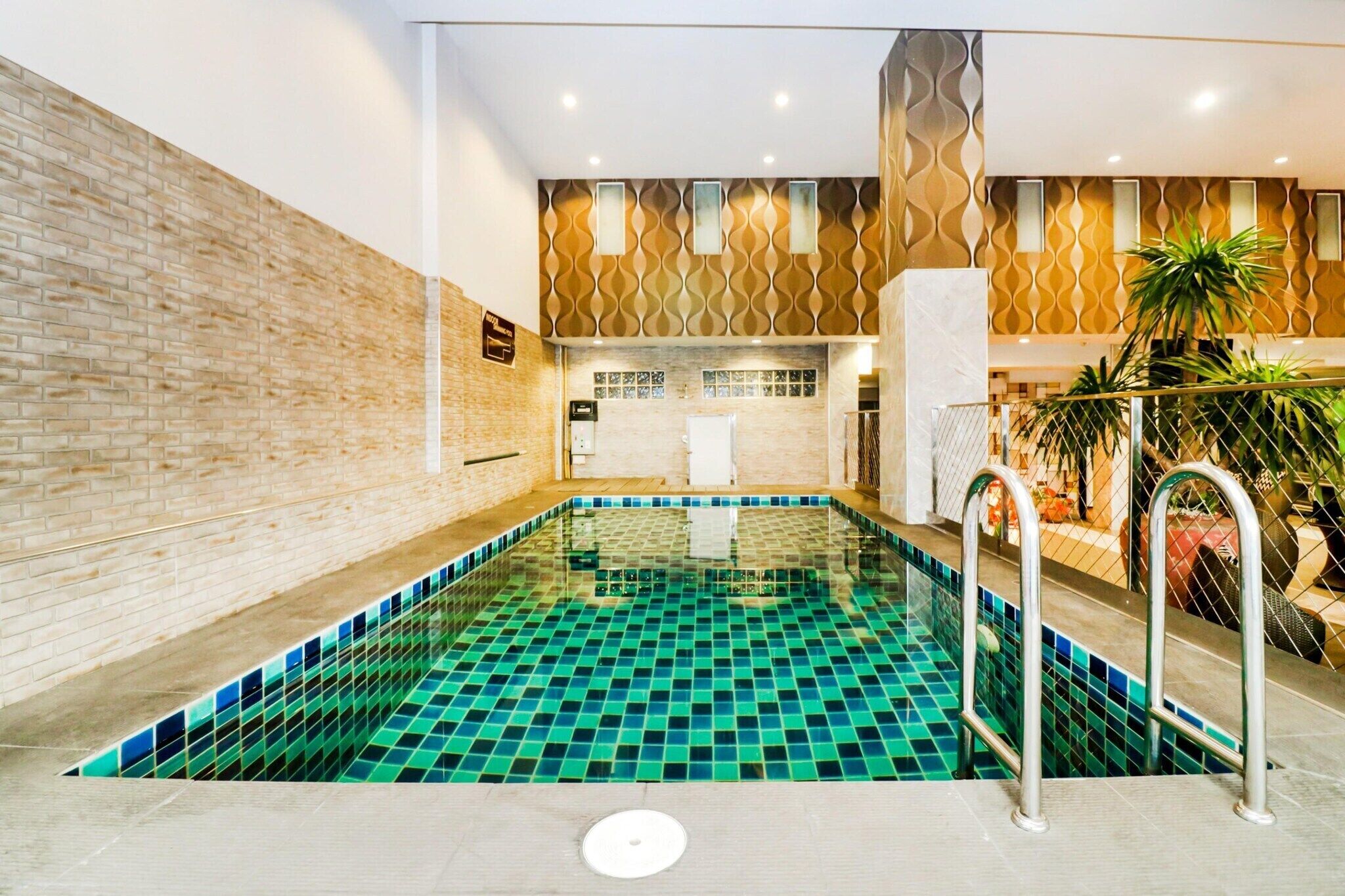 Ein Schwimmbecken mit Fliesenboden und Metallleiter.