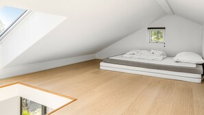 A small, white, sloped-roof room with a bed, a window, and a skylight. - "Merve" - 250m from the sea by Interhome (Odder)