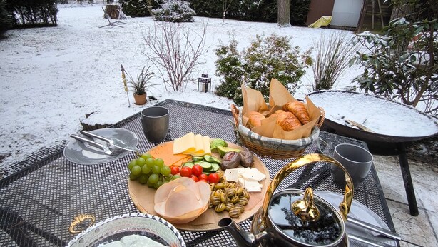 Ein Tisch im Freien mit Speisen und einem heißen Getränk.