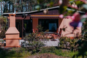 A modern house with a patio, outdoor seating, and a chimney. - Holiday Home 'Ferienhaus Nachtigall' with Private Terrace, Garden and Wi-Fi (Schorfheide)