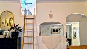 A room with a loft bed, a ladder, a mirror, a dresser, and a brown leather couch. - The Tidehouse, Relax with the whole family at this peaceful place to stay. (Laurenceton)