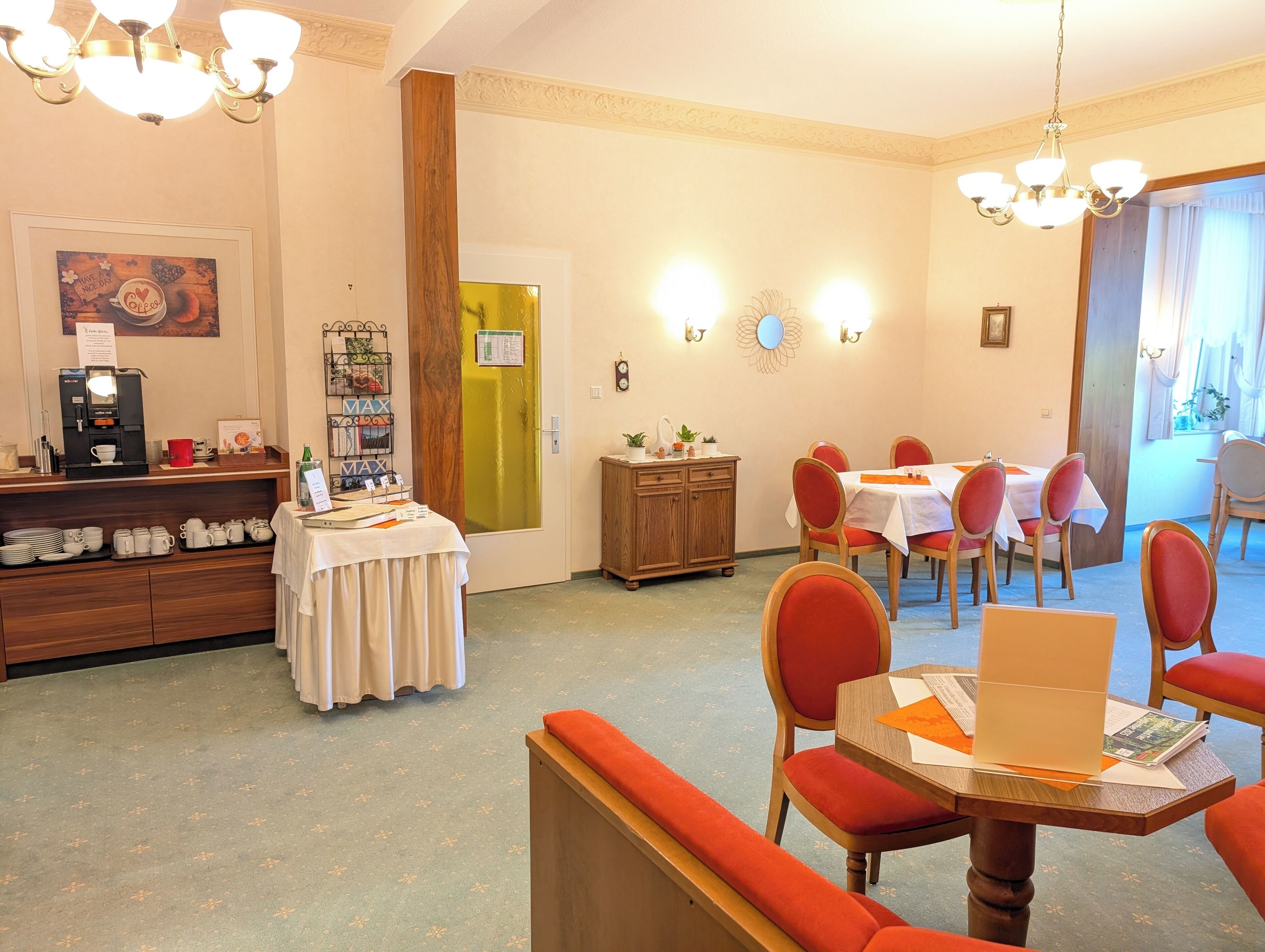 Un comedor con una máquina de café, una mesa de buffet y un mueble de madera.