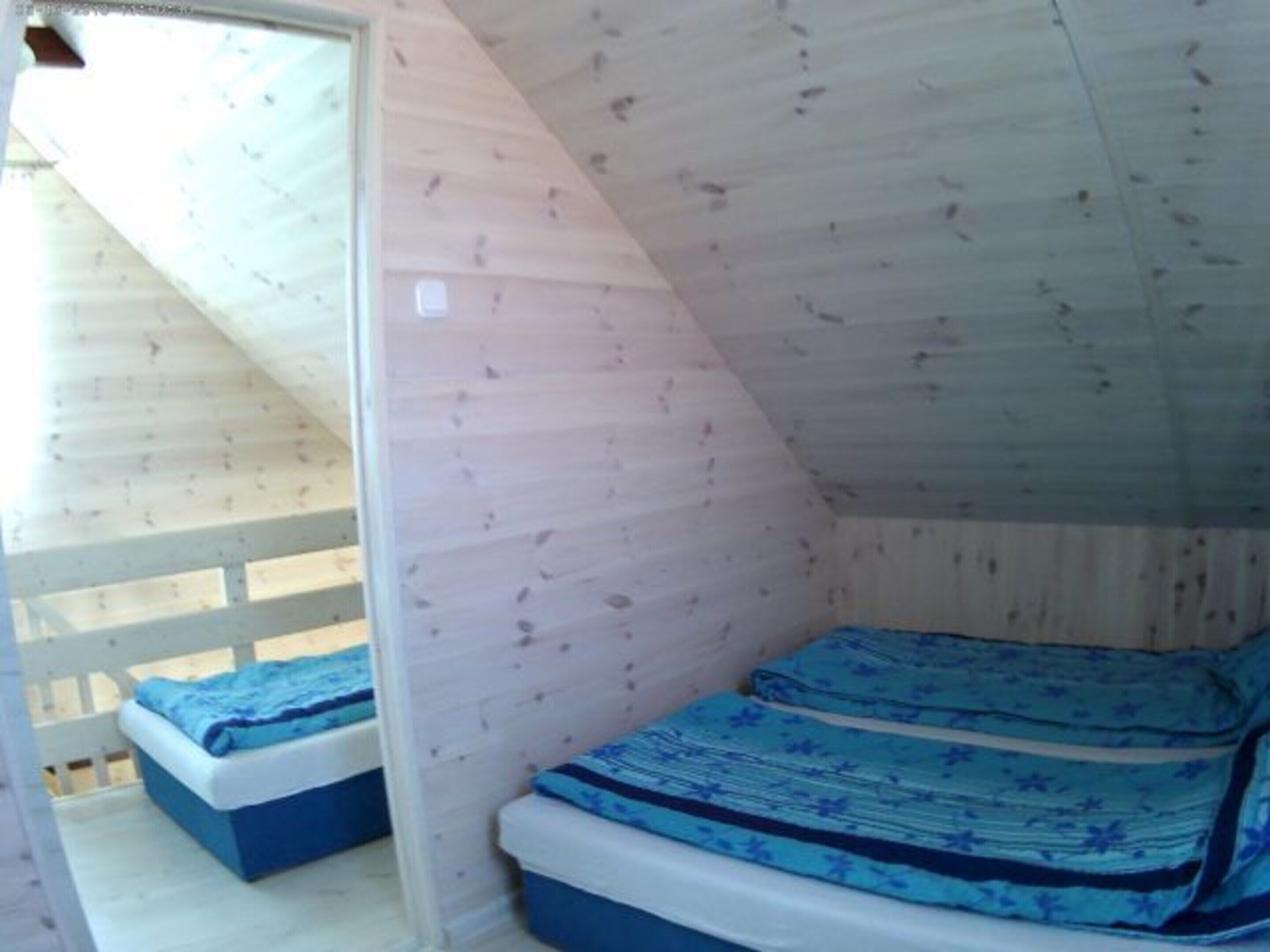 Ein kleiner, abgeschlossener Raum mit schrägverdeckter Decke und Etagenbett.