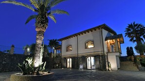 A two-story house with a stone facade, arched windows, and a balcony. - VILLA BIDDIZZA an oasis of peace and relaxation (Sicilia)